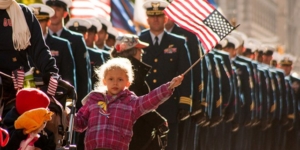 Young child waving a flag at Veterans celebration